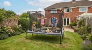 Family enjoying outdoor play together on a spacious rectangular trampoline in the garden