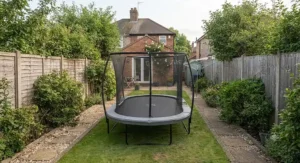 An oval trampoline positioned in a long narrow garden space
