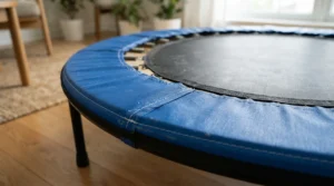 A close-up illustration focusing on the thick safety mat of a low-impact rebounder for bad knees.